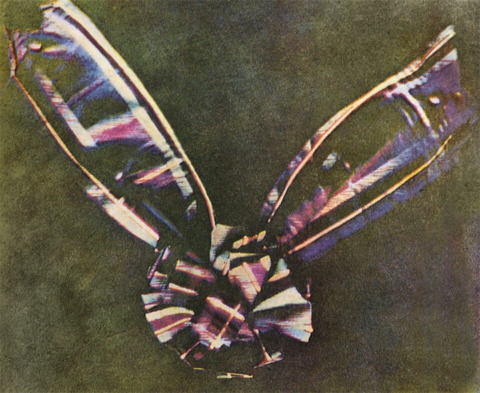 A primeira fotografia colorida: uma fita de tartã, apresentada por Maxwell em 17 de maio de 1861. A imagem foi obtida projetando três fotografias em preto e branco, tiradas com filtros vermelho, verde e azul.